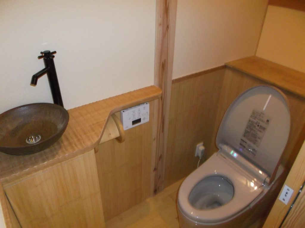 バンブー（竹）フロアにバンブーの腰壁。タモの手洗いカウンターに焼き物の手洗い鉢。タンクレストイレを設置